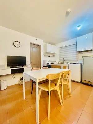a kitchen with a white table and chairs in a room at 2BR Relaxing Oasis with pool access Sorrento Oasis in Manila