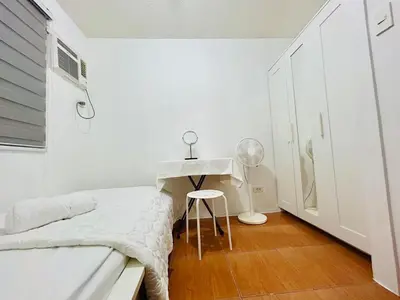 a white bedroom with a bed and a desk at 2BR Relaxing Oasis with pool access Sorrento Oasis in Manila