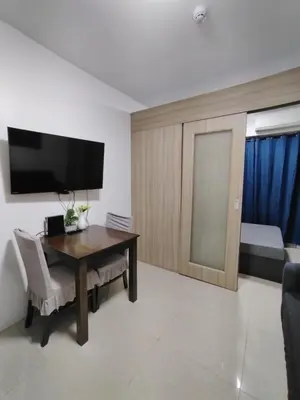 a living room with a table and a television at 2 Bedrooms 1CR Shore 1 Residences upto 7 person-15mins walk to MOA in Manila