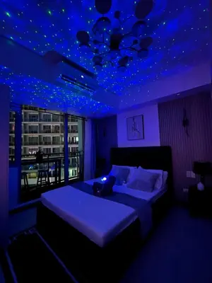a bedroom with a bed with blue lights on the ceiling at R&D comfy staycation in Manila