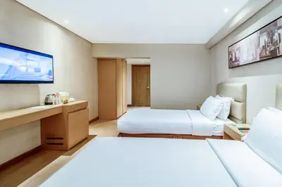 a hotel room with two beds and a flat screen tv at Jinjiang Inn - Ortigas in Manila
