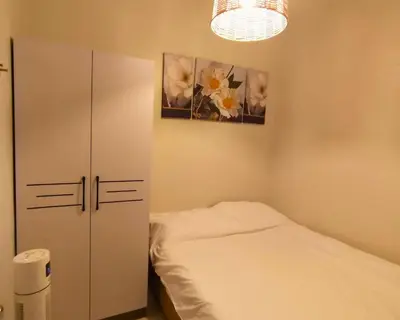 a bedroom with a bed and a cabinet and flowers at Las Vegas of the Philippines in Pasay Manila Luxury Near NAIA Airport x Solaire x Okada x City of Dreams and Casinos Enjoy FREE Pool Access n HighSpeed WIFI and Netflix Comfort with ResortType Living Secure Your Limited Offer This Month in Manila