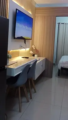 a room with a desk with a tv on the wall at Spacious Homes at Shore Residence Near Mall of Asia in Manila
