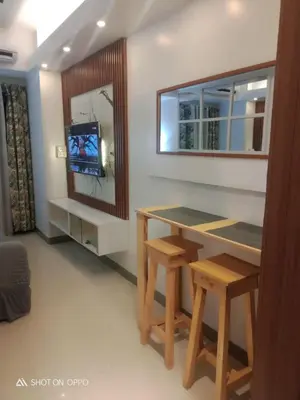 a living room with a table and a tv at Spacious Homes at Shore Residence Near Mall of Asia in Manila
