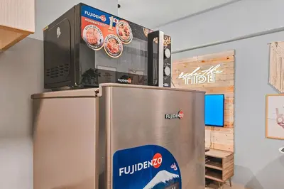 a refrigerator with a microwave on top of it at Luxury 2br in Makati with Billiard & Netflix in Manila