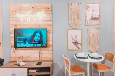 a living room with a tv on a wall at Luxury 2br in Makati with Billiard & Netflix in Manila