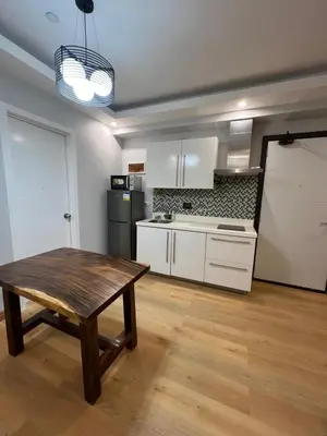 a kitchen with a wooden table in a room at Acqua Escape in Manila