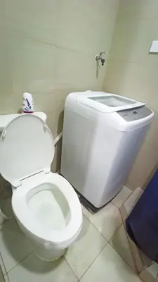 a bathroom with a white toilet in a room at Divine Staycation in Manila