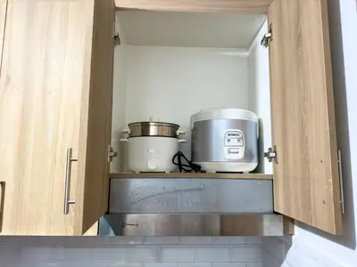 a kitchen with two appliances sitting on a shelf at Divine Staycation in Manila