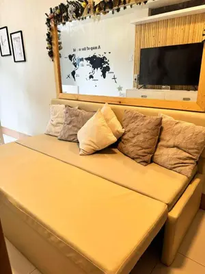 a brown couch with pillows on it in a room at CASA BELLA - Shore 3 MOA, Pasay in Manila