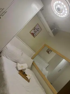 a small room with a bed and a mirror at CASA BELLA - Shore 3 MOA, Pasay in Manila