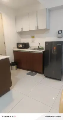 a kitchen with a sink and a black refrigerator at The Embassy Pods in Manila
