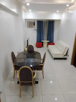 a living room with a table and chairs and a couch at The Embassy Pods in Manila