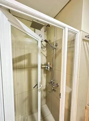 a shower with a glass door in a bathroom at Condo near MOA and NAIA in Manila