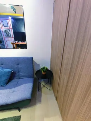 a living room with a blue couch and a table at Shore 2 Tower 3 Modern Loft Near Mall of Asia in Manila