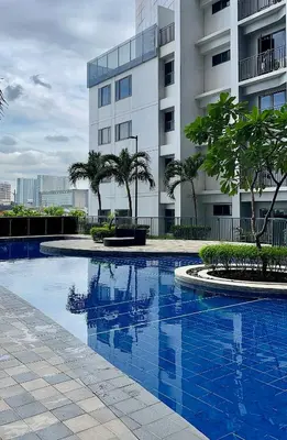 a blue swimming pool in front of a building at Shore 2 Tower 3 Modern Loft Near Mall of Asia in Manila