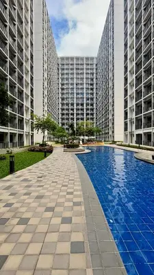 a swimming pool in the middle of two tall buildings at Shore 2 Tower 3 Modern Loft Near Mall of Asia in Manila
