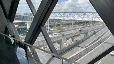 a view of a bridge from a glass window at One Palm Tree Villas Studio w fast WiFi, across from NAIA Terminal 3 in Manila