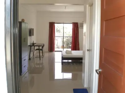 a hallway with a room with a bed and a table at The Palines Apartment Hotel near Brittany Palazzo Villar City in Manila