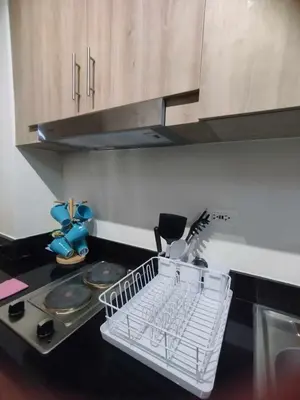 a kitchen with a dish drying rack on the counter at Cozy Apartment in Mall of Asia in Manila