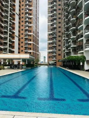 a swimming pool in the middle of two tall buildings at 1 BEDROOM Staycation in Pasay in Manila