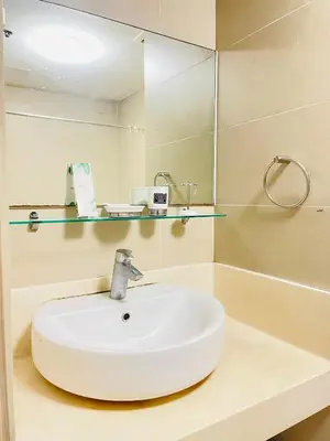 a bathroom with a white sink and a mirror at Cozy 1 Bedroom Condo Unit in Manila