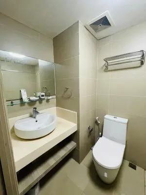 a bathroom with a white toilet and a sink at Cozy 1 Bedroom Condo Unit in Manila