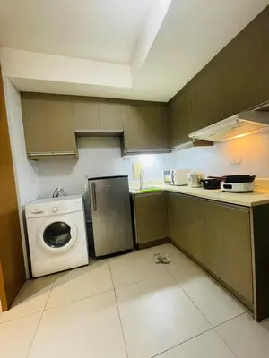 a kitchen with a washing machine and a washer at Cozy 1 Bedroom Condo Unit in Manila