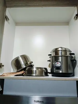 two pots and pans sitting on top of a stove at Coast Residences in Manila