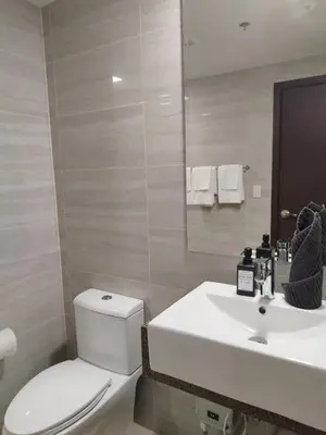 a bathroom with a white sink and a toilet at Savvy Suites Combined 5BR near Okada in Manila