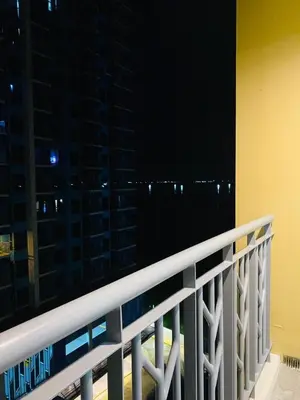 a balcony with a view of a city at night at Savvy Suites Combined 5BR near Okada in Manila
