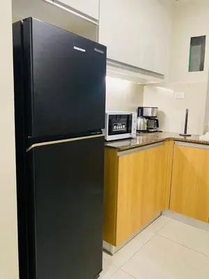 a black refrigerator in a kitchen with a microwave at Savvy Suites Combined 5BR near Okada in Manila