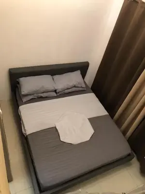 a bed with a black frame and pillows on it at HY Place Manila in Manila