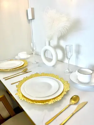 a table with white plates and gold utensils at Air Residences - Elevate Escapes Makati, central location in Manila