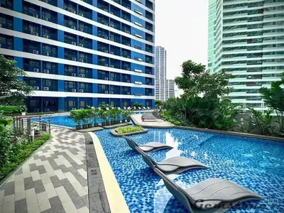 a swimming pool with lounge chairs in a building at Air Residences - Elevate Escapes Makati, central location in Manila