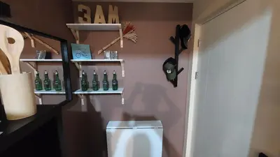 a bathroom with a toilet and shelves on the wall at Affordable Whole 2 bedroom Condo high floor BGC in Manila