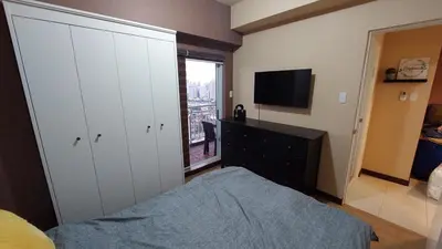 a bedroom with a bed and a flat screen tv at Affordable Whole 2 bedroom Condo high floor BGC in Manila