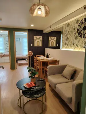 a living room with a couch and a table at Cadence Place 2BR Pasig Condo for upto 6pax with Free Parking in Manila