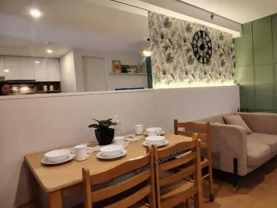 a dining room table with chairs and a couch at Cadence Place 2BR Pasig Condo for upto 6pax with Free Parking in Manila