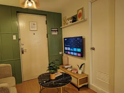 a living room with a table and a tv at Cadence Place 2BR Pasig Condo for upto 6pax with Free Parking in Manila