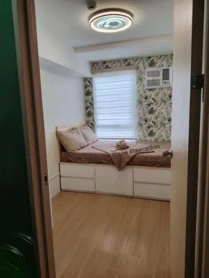 a small bedroom with a bed and a window at Cadence Place 2BR Pasig Condo for upto 6pax with Free Parking in Manila