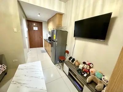 a living room with a tv on a wall with stuffed animals at Kathys Crib 11th flr at Shell Residence in Manila