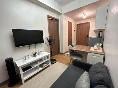 a living room with a couch and a flat screen tv at Ohana Staycation in Manila