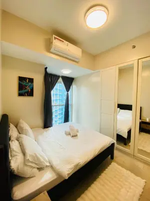 a bedroom with a large bed and a window at Serendipity staycation in Manila