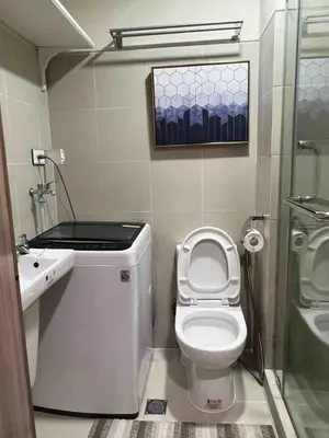 a small bathroom with a toilet and a sink at Stylist hideaway in d heart of MOA in Manila