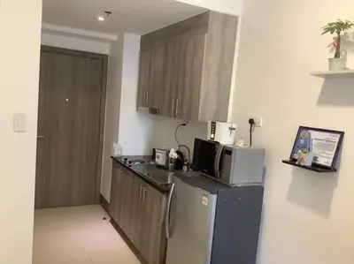 a kitchen with a refrigerator and a microwave at S Residence 3,Mall of Asia Area in Manila