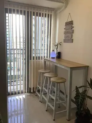 a kitchen with a table and stools in a room at S Residence 3,Mall of Asia Area in Manila