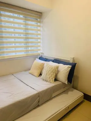 a bed sitting in a room with a window at S Residence 3,Mall of Asia Area in Manila