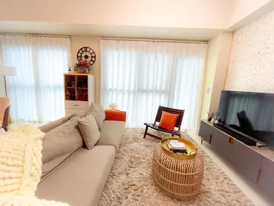 a living room with a couch and a flat screen tv at Luxury Apartment near Okada Manila and Solaire in Manila