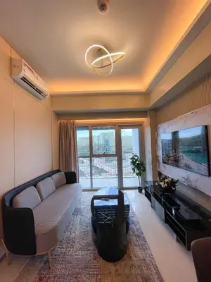 a living room with a couch and a flat screen tv at Luxury 1BR across Okada, Solaire in Manila